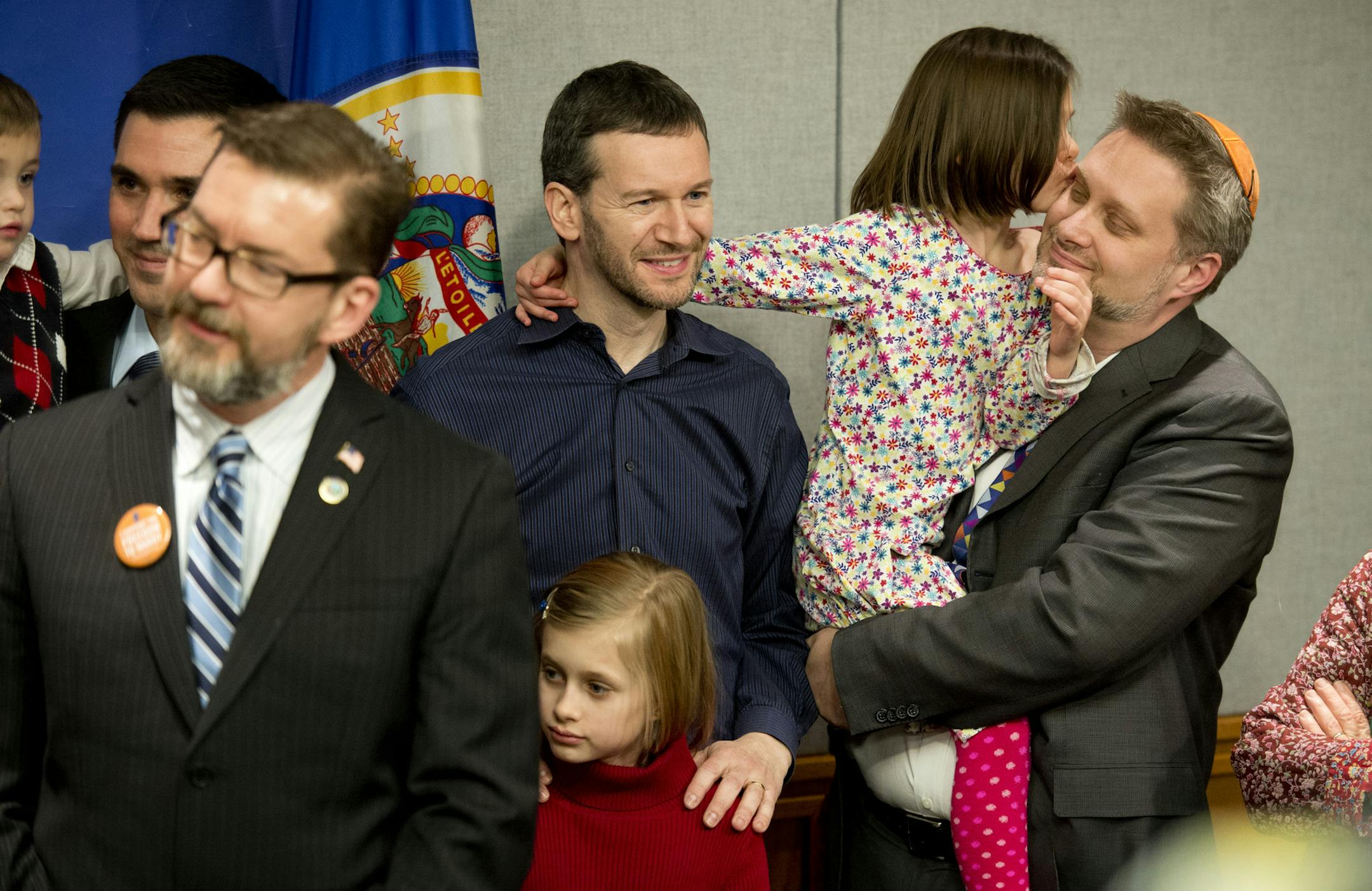 Rabbi Michael Latz got a kiss from his daughter after speaking at a Feb. 27, 2013, press conference introducing a bill to legalize same-sex marriages in Minnesota. He was there with husband Michael Simon, center. Surrounded by same-sex couples and their children, Sen. Scott Dibble and Rep. Karen Clark introduced their bill.
