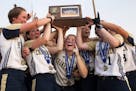 Marybeth Olson gestured victoriously from below the championship trophy while helping teammates celebrate their Class 4A title victory over Buffalo. O