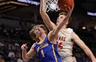 Wayzata's Hayden Tibbits (1) lays the ball up around the reach of Wyatt Hawks (34) in the first half. Tibbits led the field with 17 points in the Troj