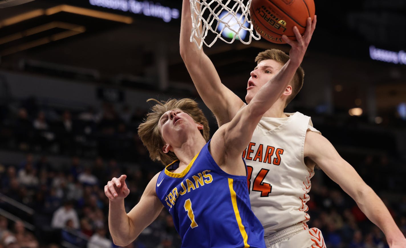 Wayzata's Hayden Tibbits (1) lays the ball up around the reach of Wyatt Hawks (34) in the first half. Tibbits led the field with 17 points in the Trojans' 81-61 win. Photo by Cheryl A. Myers, SportsEngine