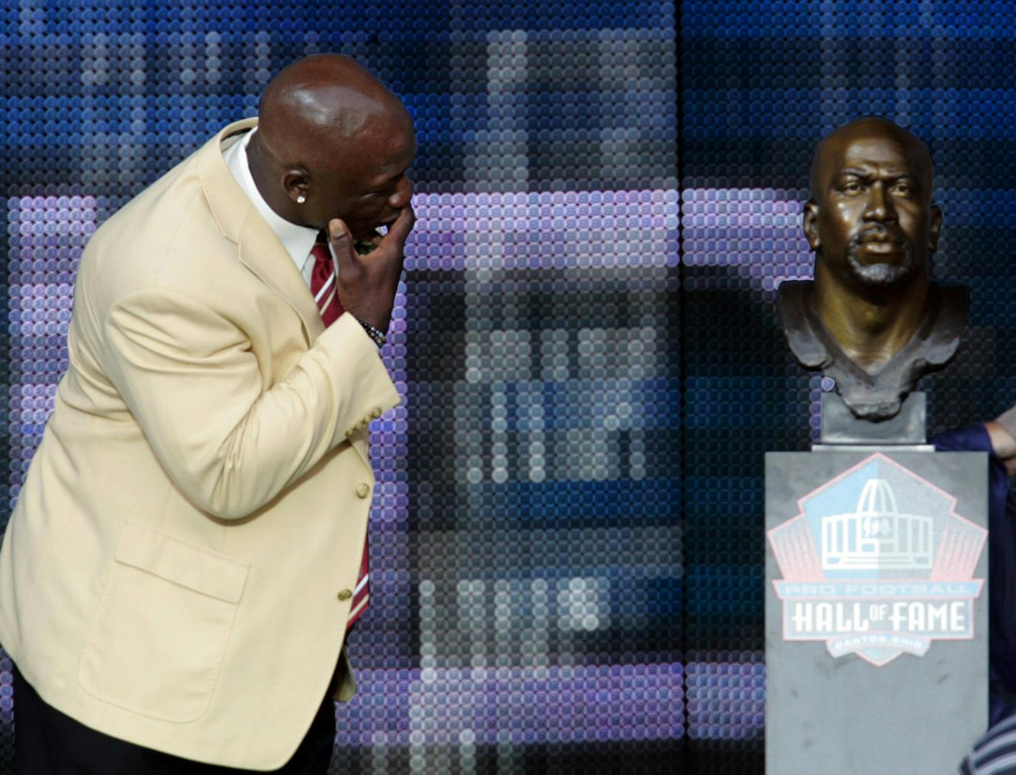 John Randle of the Minnesota Vikings examines his bust after unveiling it with his presenter John Teerlinck, former defensive line coach for the Minnesota Vikings, during the Pro Football Hall of Fame Enshrinement ceremony at Fawcett Stadium in Canton, Ohio, Saturday, August 7, 2010. (Mike Cardew/Akron Beacon Journal/MCT) ORG XMIT: MIN2015101518144207