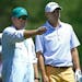 Bill Haas, right, listens to his caddie prior to hitting from the 12th tee during the first round of the Masters Tournament, Thursday, April 10, 2014,