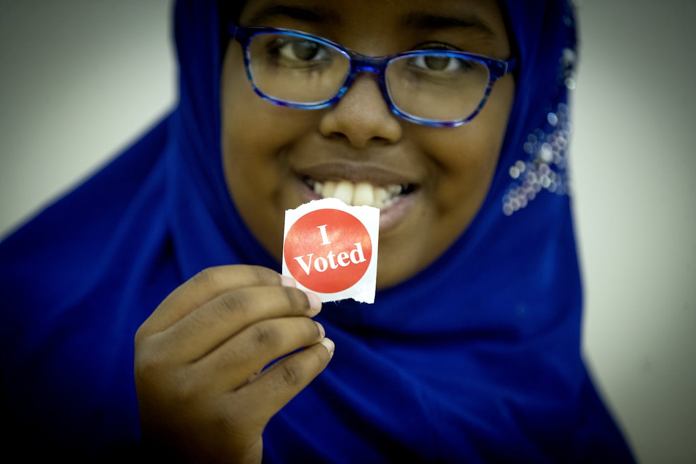 Amina Said proudly held up her mother's "I voted" sticker after her mother Weris Said voted at the Brian Coyle Community Center on primary election day, Tuesday, August 14, 2018 in Minneapolis.