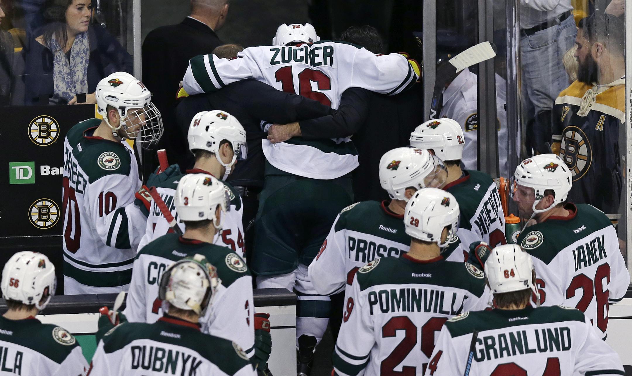 Minnesota Wild left wing Jason Zucker (16) is helped from the ice after an injury in the final seconds of the third period of an NHL hockey game against the Boston Bruins in Boston Thursday, Nov. 19, 2015. (AP Photo/Charles Krupa)