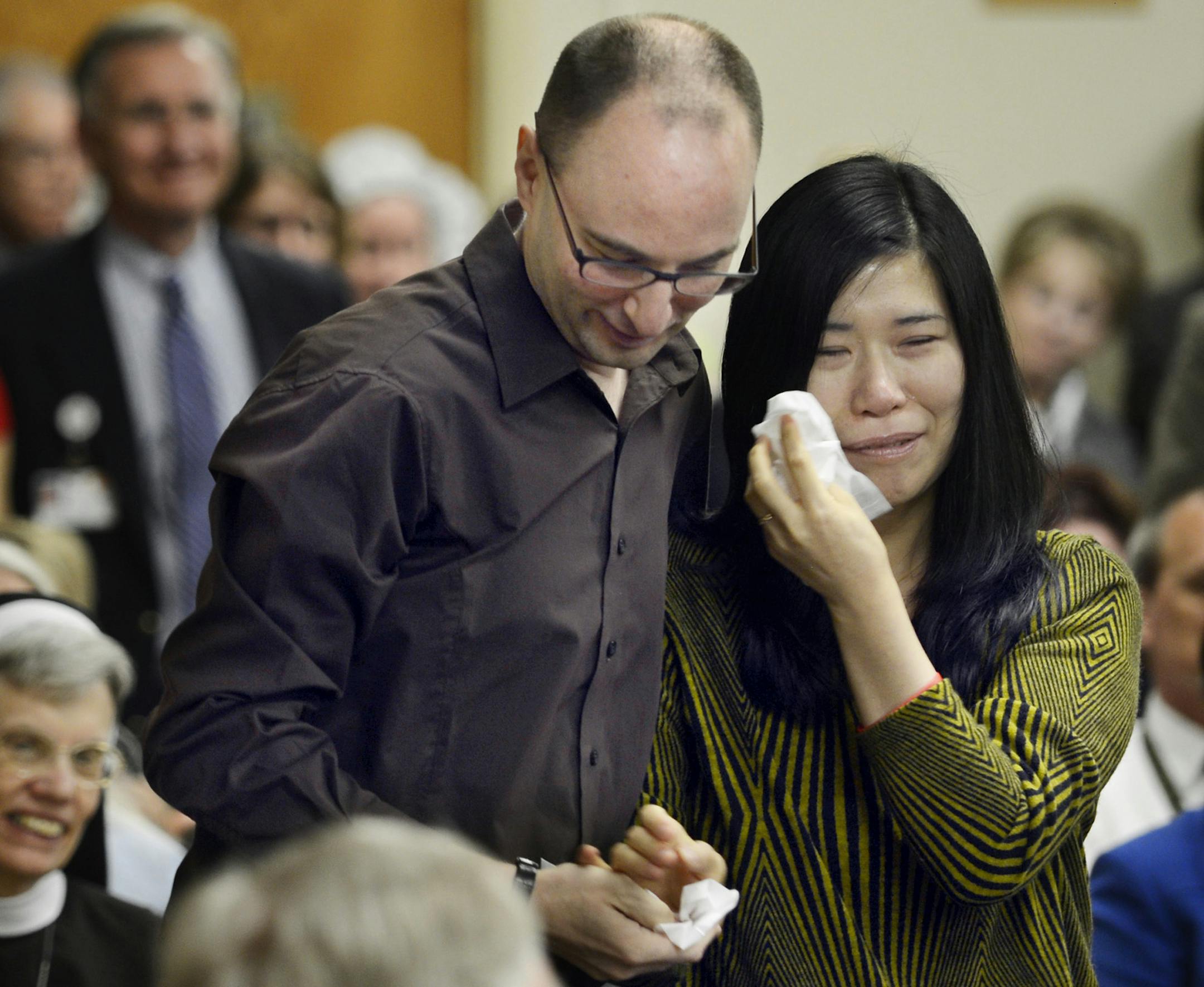 Darryl Warren and his wife, Lee Young-mi, tearfully stand Tuesday April 30, 2013, after being introduced at a press conference in at Children's Hospital of Illinois, in Peoria, Ill. The couple are the parents of 2-year-old Hannah Warren who received a new windpipe at the hospital in a landmark transplant operation April 9, 2013. Hannah was born in South Korea without a windpipe but received a new one made from her own stem cells. She is the youngest patient ever to get the experimental treatment
