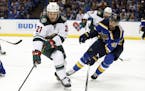 Minnesota Wild's Ryan White (21) controls the puck as St. Louis Blues' Robert Bortuzzo (41) defends during the first period in Game 3 of an NHL hockey