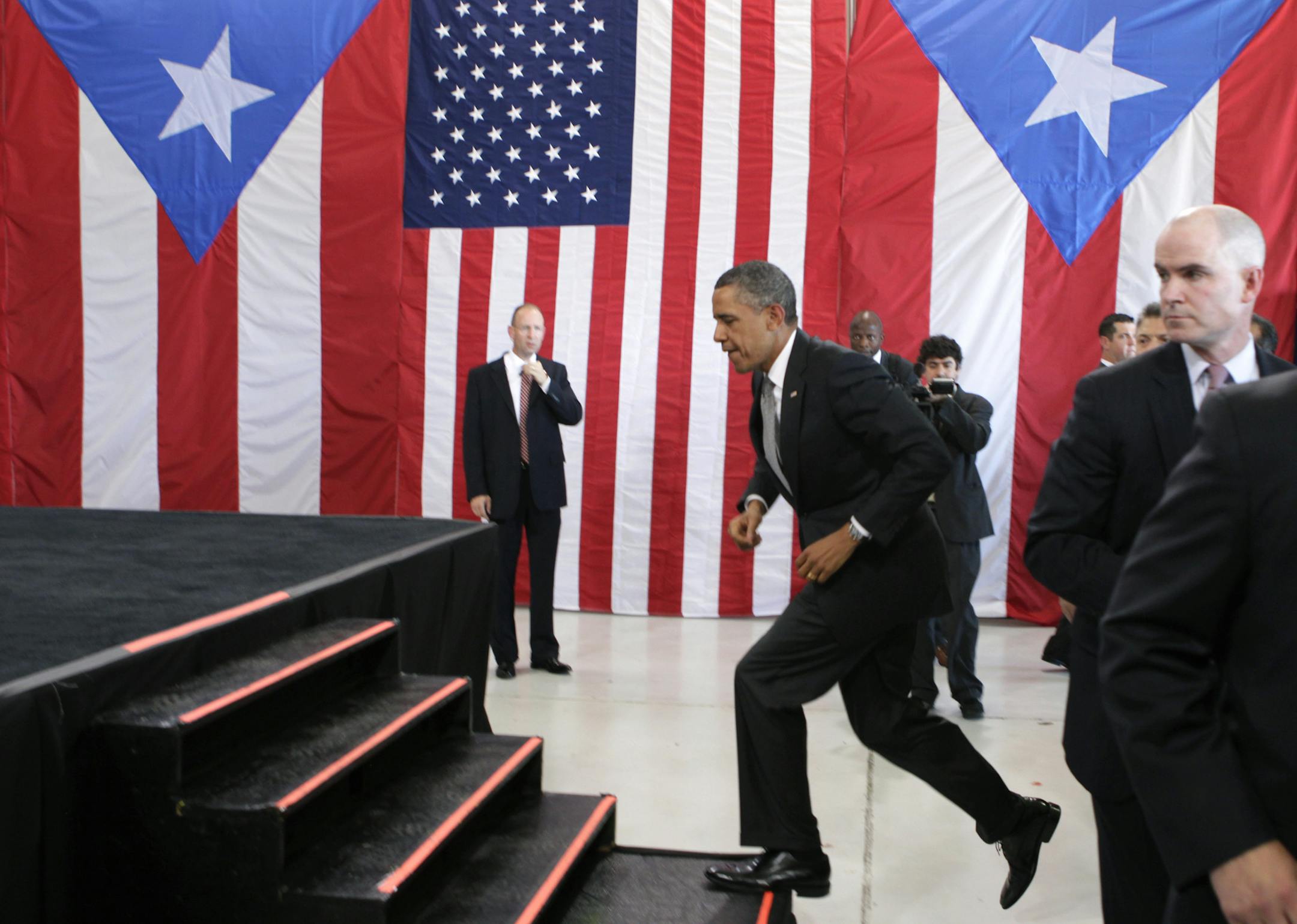 FILE - This June 14, 2011, file photo, President Barack Obama arrives at an airport hanger at Muniz Air National Guard Base, in San Juan, Puerto Rico. Mark Connolly, the second-in-command on President Barack Obama's security detail is far right. The Homeland Security Department is investigating two senior Secret Service agents accused of crashing a car into a White House security barrier, an agency spokesman says. (AP Photo/Carolyn Kaster, File)
