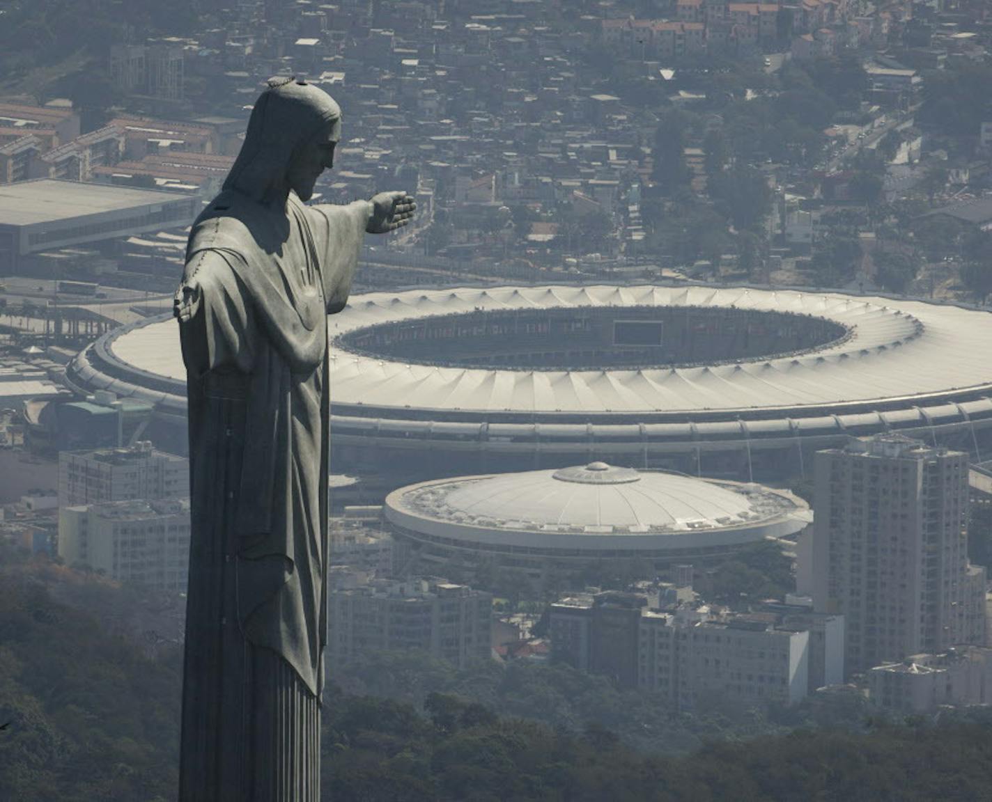 The Christ the Redeemer statue stands above Maracana stadium in Rio de Janeiro, Brazil, Monday, Aug. 1, 2016. The Summer Olympics start Aug. 5. (AP Photo/Felipe Dana)