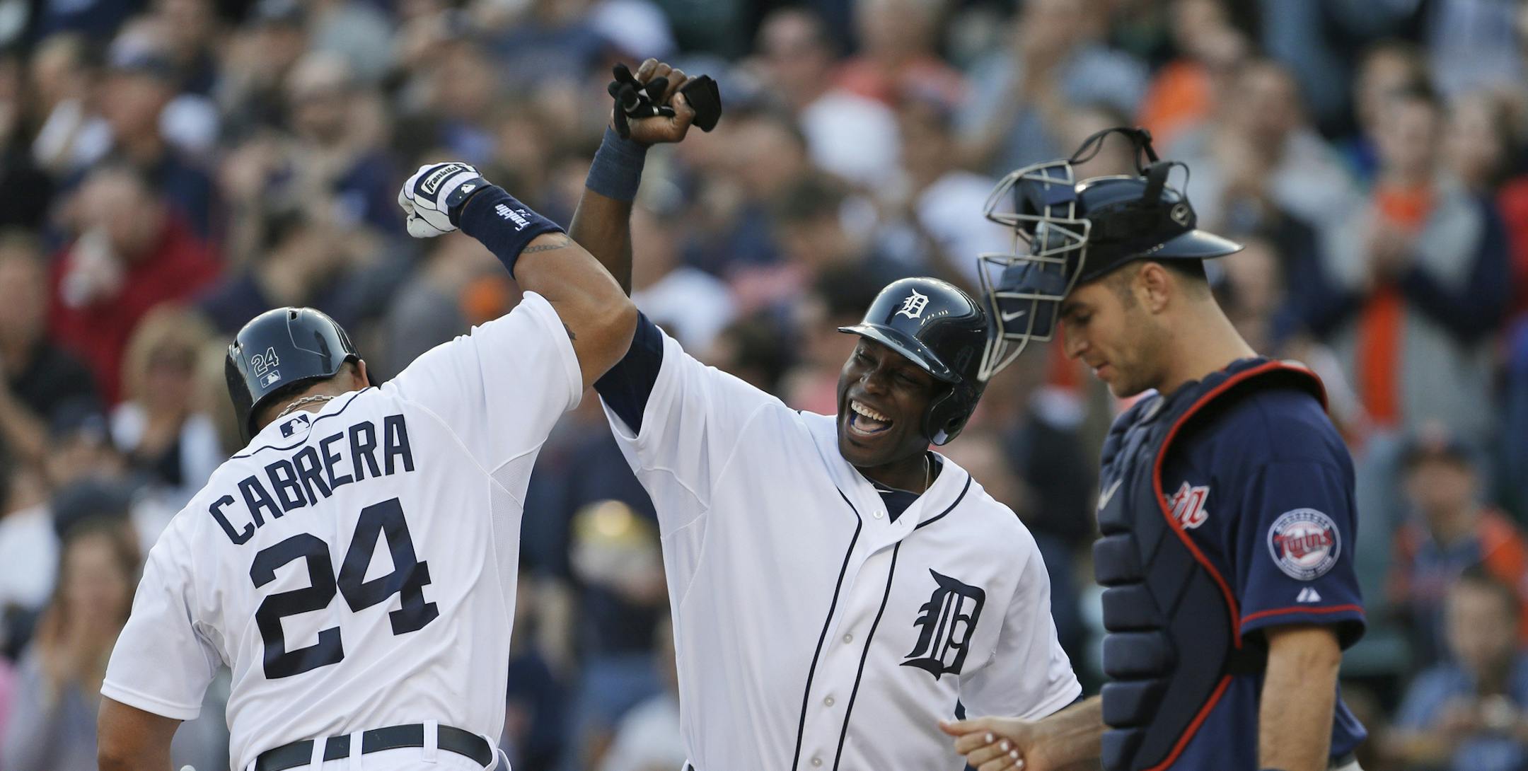 Detroit Tigers' Miguel Cabrera is congratulated after his two-run home run by teammate Torii Hunter in front of Minnesota Twins catcher Joe Mauer during the first inning of a baseball game in Detroit, Tuesday, April 30, 2013. (AP Photo/Carlos Osorio)
