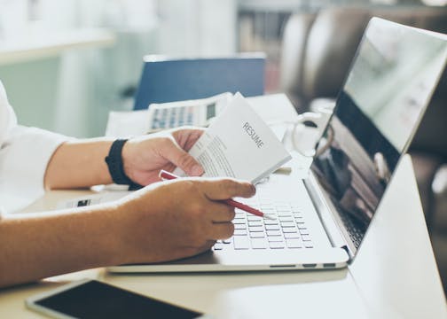 Business man review his resume on his desk, laptop computer, calculator and cup of coffee,Seleted focus. istock photo