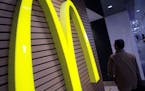 FILE - In this Dec. 17, 2014, file photo, a man walks by a McDonald's restaurant in Tokyo. McDonald&#xed;s Corp. on Thursday, July 23, 2015, reported 