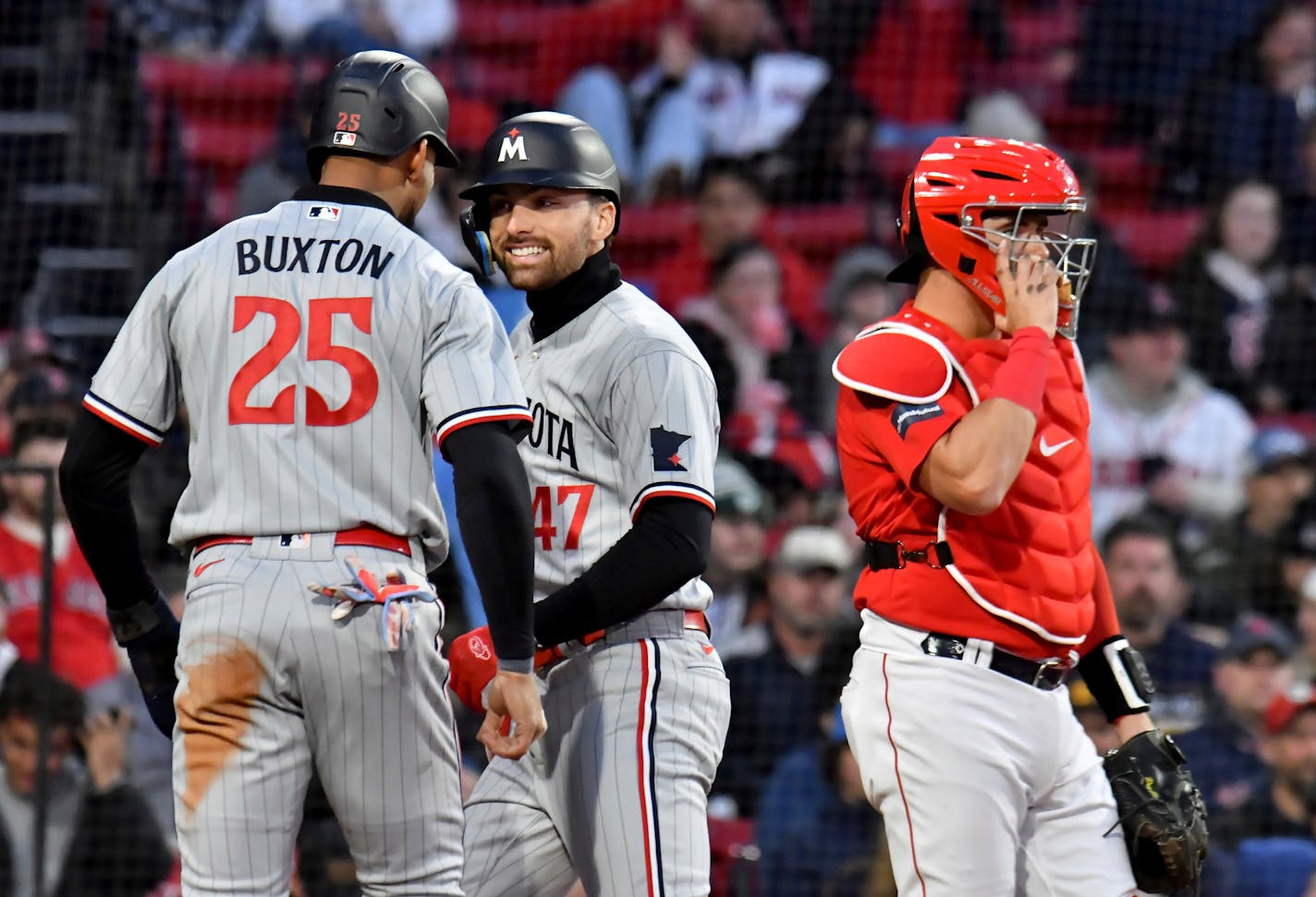 Minnesota Twins' Edouard Julien (47) smiles at Byron Buxton after Julien hit a two-run home run against the Boston Red Sox during the first inning of a baseball game at Fenway Park, Wednesday, April 19, 2023, in Boston. (AP Photo/Mark Stockwell)