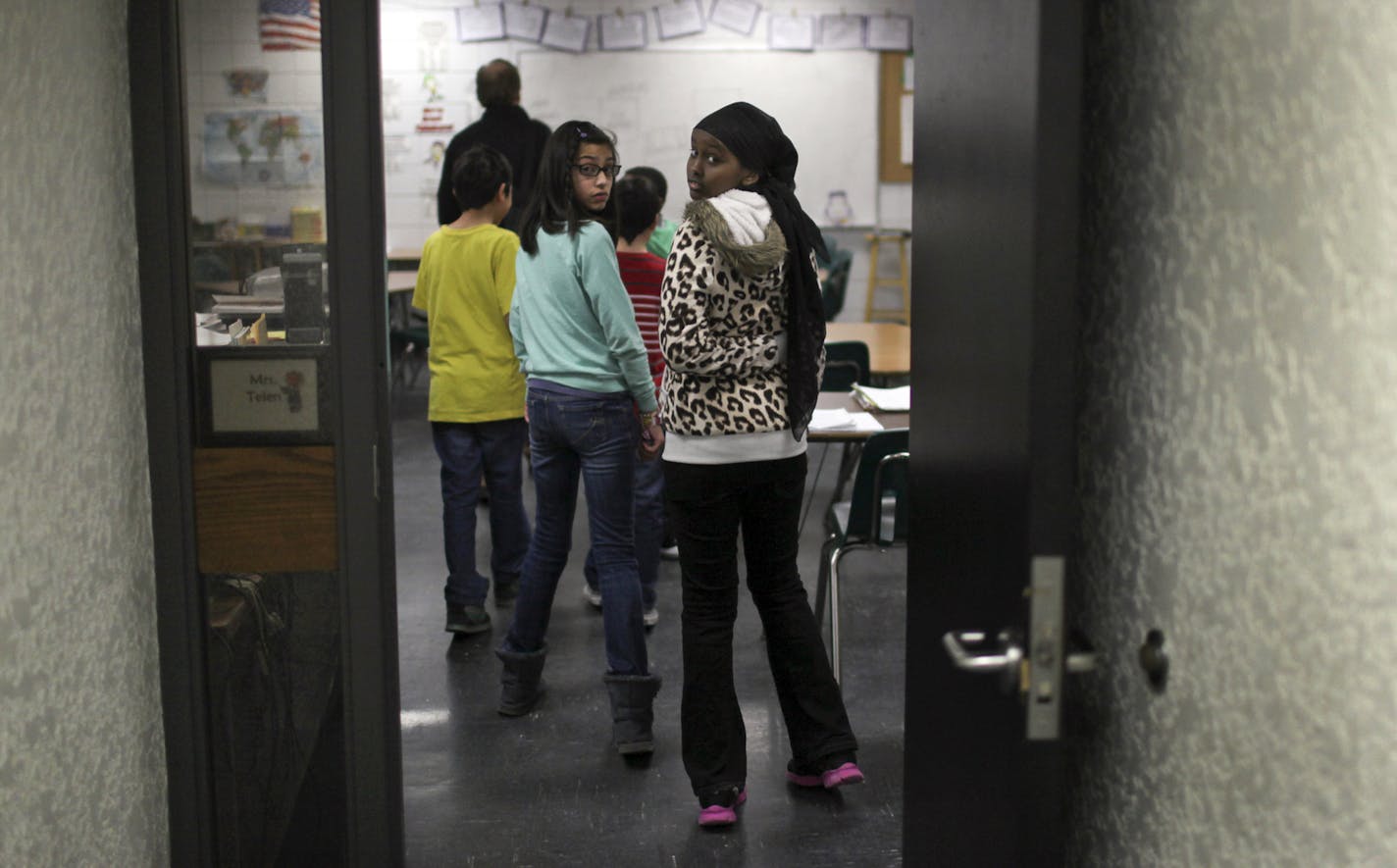 Fifth graders Hibaaq Mahamed, right, and Krystell Serrano, middle, follow their co-fifth grade math teacher and math interventionist Paul Berge into a classrooom. Fifth grade students in his class used iPads and an app called Socrative to test students and get immediate feedback on how they are doing Wednesday, Feb. 27, 2013, in Burnsville, MN.] (DAVID JOLES/STARTRIBUNE) djoles@startribune.com There is too much racial diversity at Sky Oaks Elementary in Burnsville and the school district has to