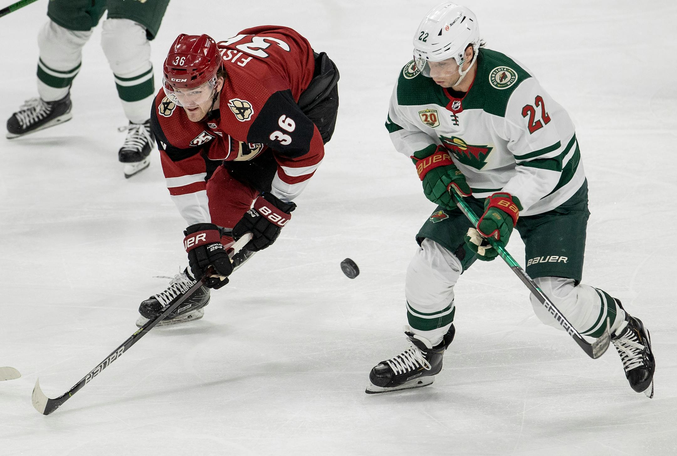 Christian Fischer (36) of the Arizona Coyotes and Kevin Fiala (22) of the Minnesota Wild fought for the puck in the second period.