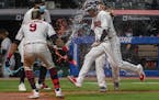 Cleveland Indians' Jordan Luplow gets drenched by Eddie Rosario and his teammates after hitting a two-run home run off Minnesota Twins relief pitcher 