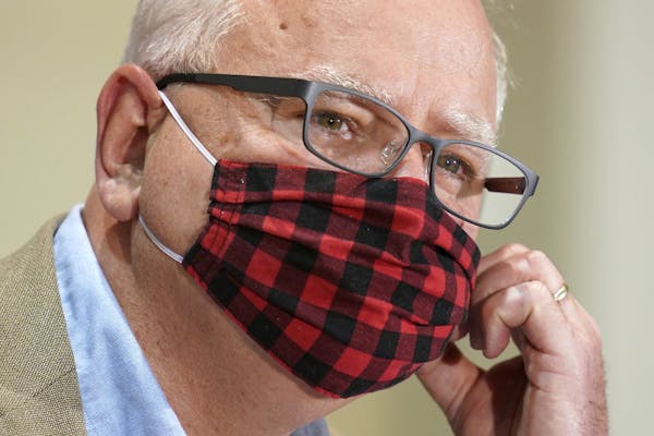 "Testing is the key to stopping the chain of the virus spreading," Minnesota Gov. Tim Walz said Tuesday. Above, he wore a buffalo plaid cloth mask dur