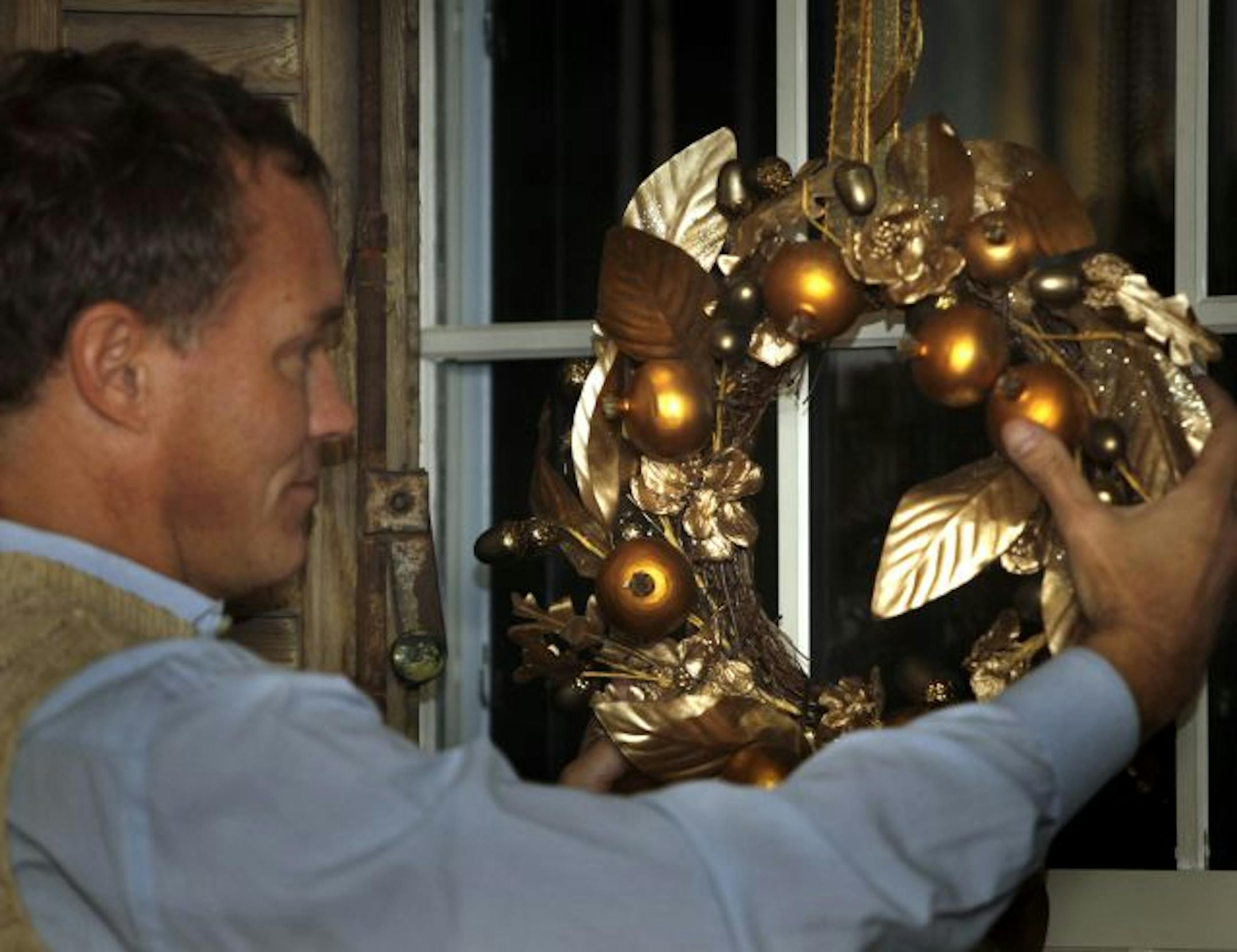 John Lassila adjusted a wreath; he hangs them on each window of his Minneapolis home.