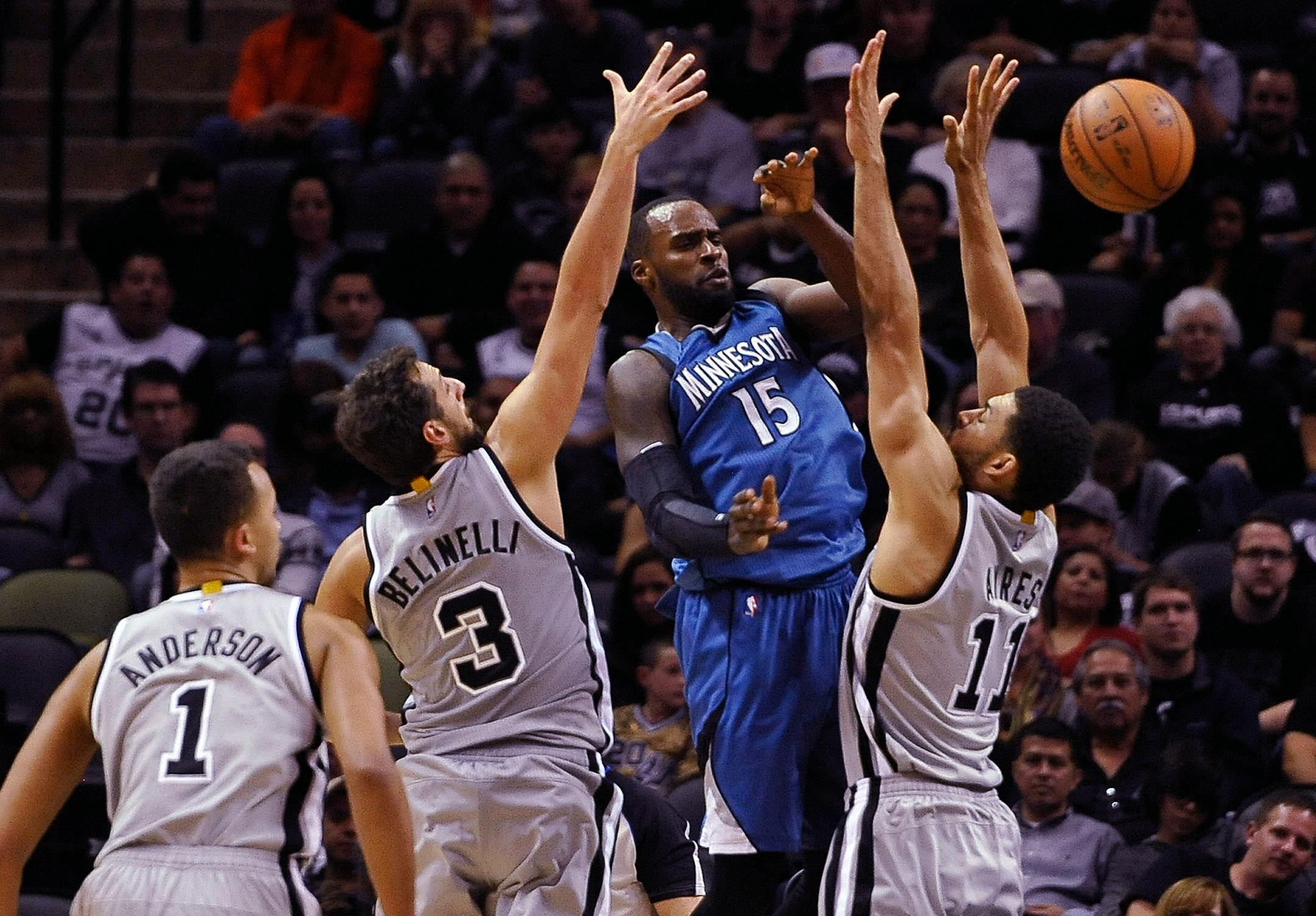 Minnesota Timberwolves guard Shabazz Muhammad is defended by San Antonio Spurs' Jeff Ayres, right, Kyle Anderson, left, and Marco Belinelli, during the second half of an NBA basketball game, Saturday, Dec. 6, 2014, in San Antonio. San Antonio won 123-101. (AP Photo/Darren Abate)
