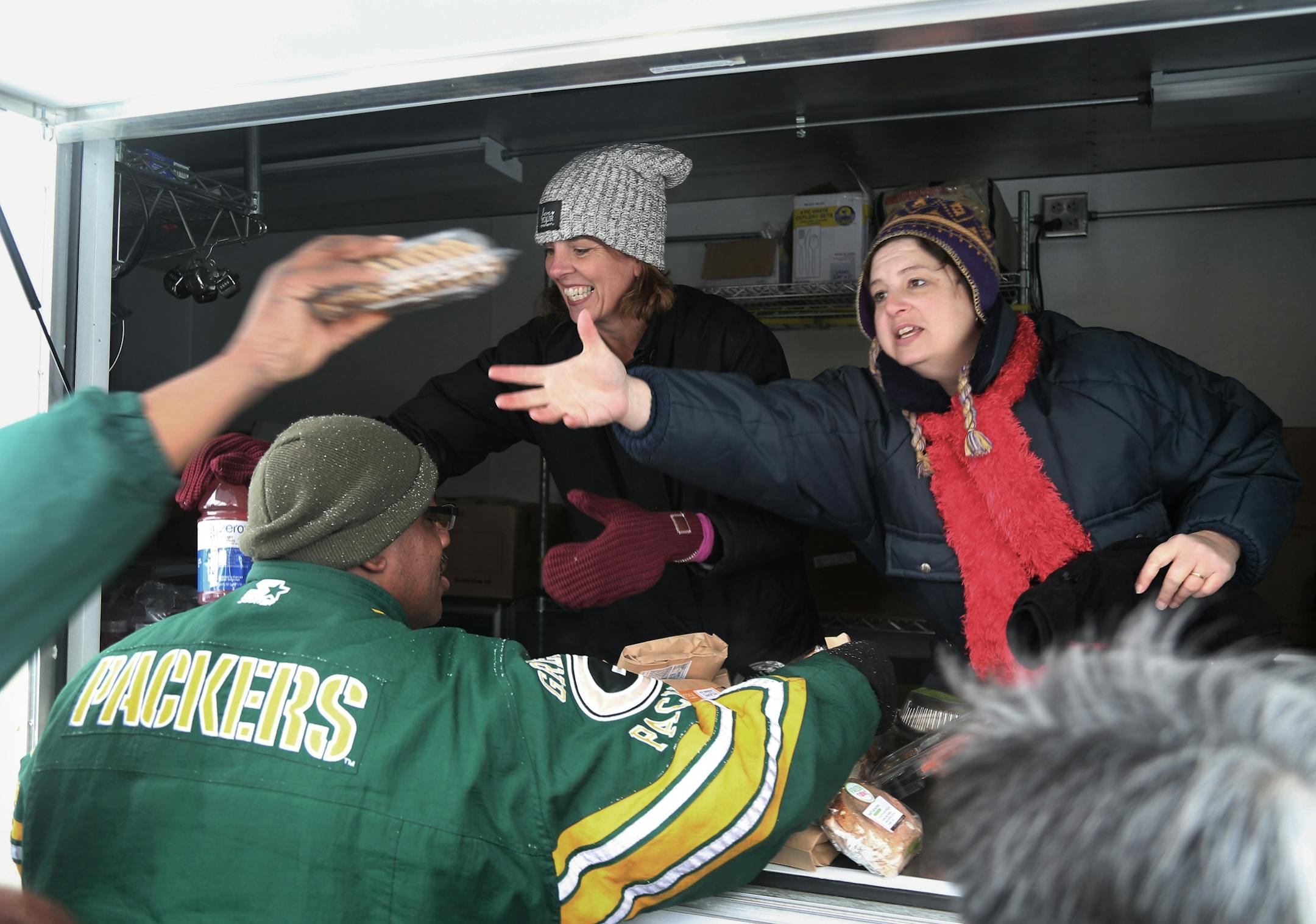 The local non-profit, Loaves and Fishes has partnered with the MSP Airport and concessionaire HMS Host to donate ready-to-eat meals not purchased at the airport, that would otherwise be thrown away, to the homeless near the Dorothy Day Center Thursday, Dec. 28, in St. Paul, MN. Here, Cathy Maes, Loaves and Fishes executive director, left, and volunteer Kristin Vondeylen, hand out sandwiches.