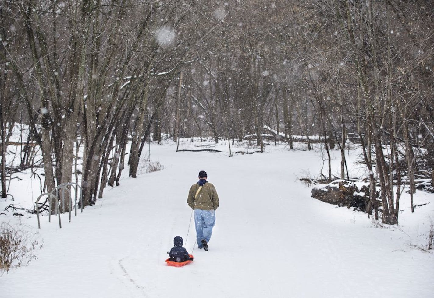 Jeff Booron of Minneapolis pulled his three-year-old son Hendrick Thaxton-Booron in a sled during a walk by a bridge that crosses to Pike Island at Fort Snelling State Park on Friday, January 8, 2015, in St. Paul , Minn.