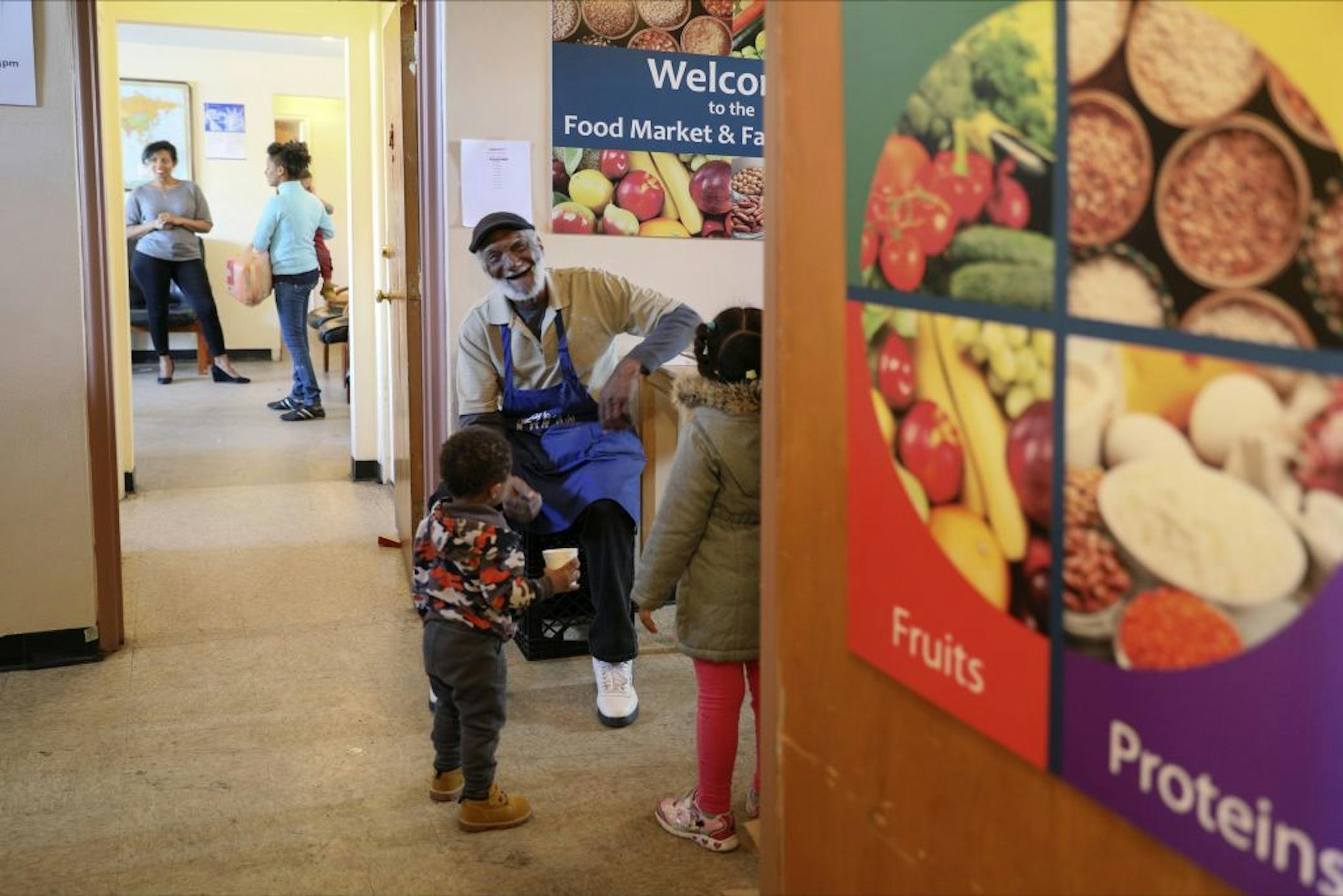 Ronnie Armstrong entertains the children outside the Sibley Manor Family Center and food market.