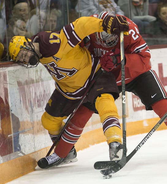 Minnesota right wing Seth Ambroz (17) vies for control over the puck with Ohio State defender Craig Dalrymple (24) and forward Tanner Fritz (16) durin