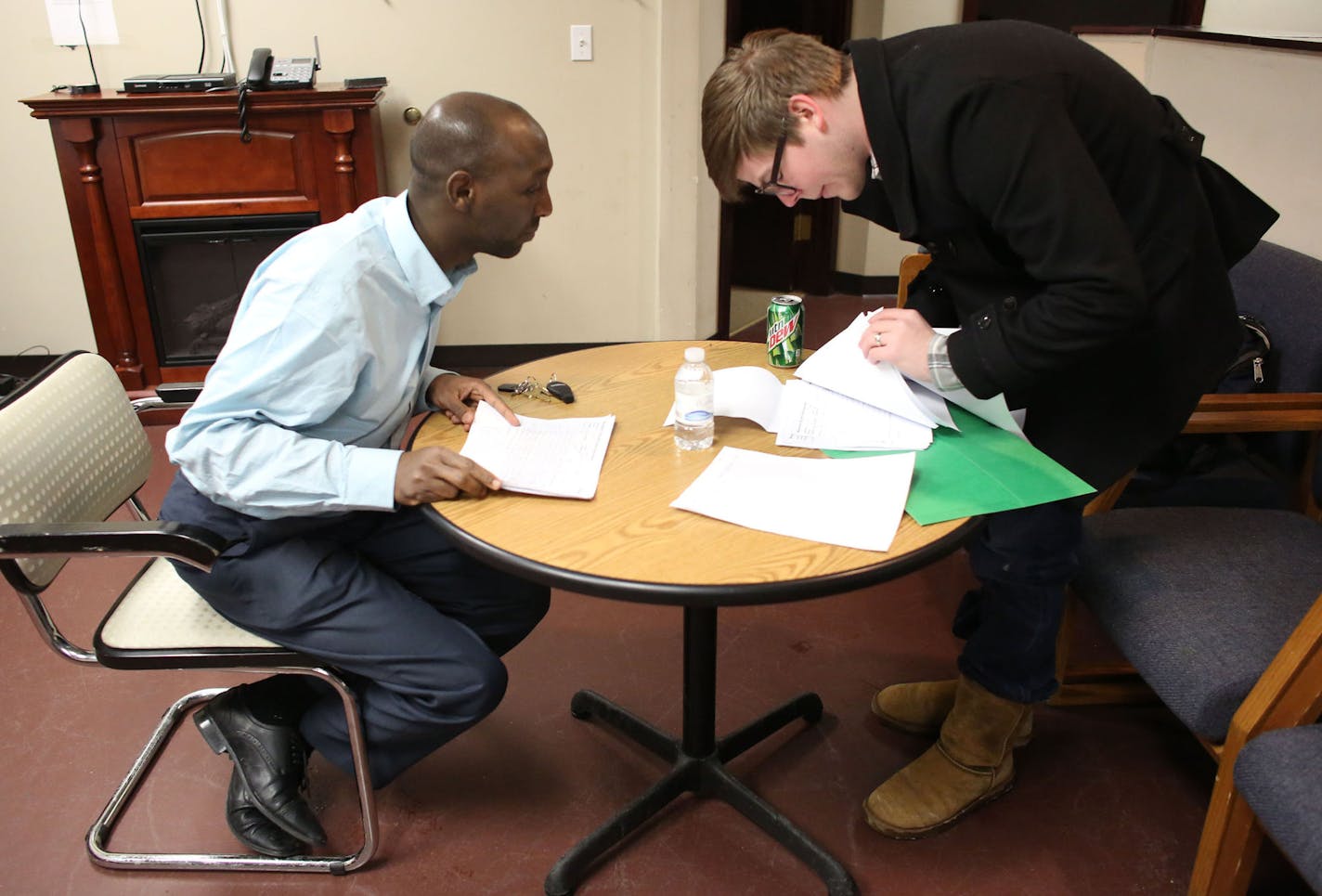 Mohamud Noor, left, and volunteer Wil Bernstrom went over phone lists of undecided delegates before making calls in Minneapolis, Wednesday, February 5, 2014. ] (KYNDELL HARKNESS/STAR TRIBUNE) kyndell.harkness@startribune.com ORG XMIT: MIN1402052005330116