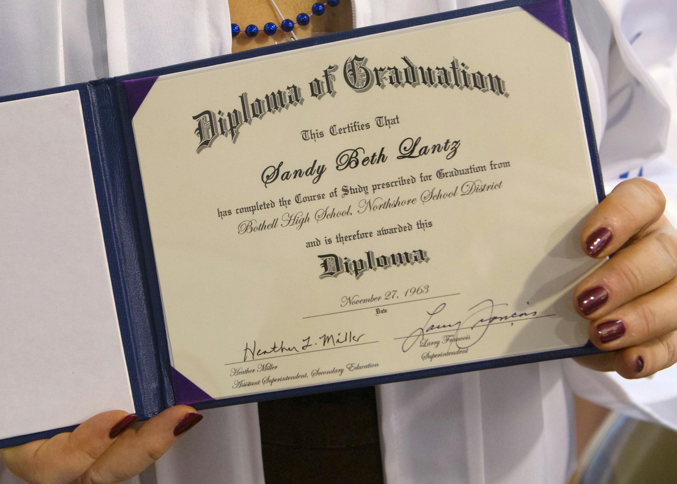 Sandra Kleven holds her BHS Class of í63 diploma, which she received Saturday, Aug. 16, 2014, during the 51st class reunion, in Bothell, Wash. Lantz was asked to leave Bothell High School in 1963, four months before graduation because she was pregnant.(AP Photo/The Seattle Times, Ellen M. Banner) OUTS: SEATTLE OUT, USA TODAY OUT, MAGAZINES OUT, TELEVISION OUT, SALES OUT. MANDATORY CREDIT TO: ELLEN M. BANNER / THE SEATTLE TIMES.