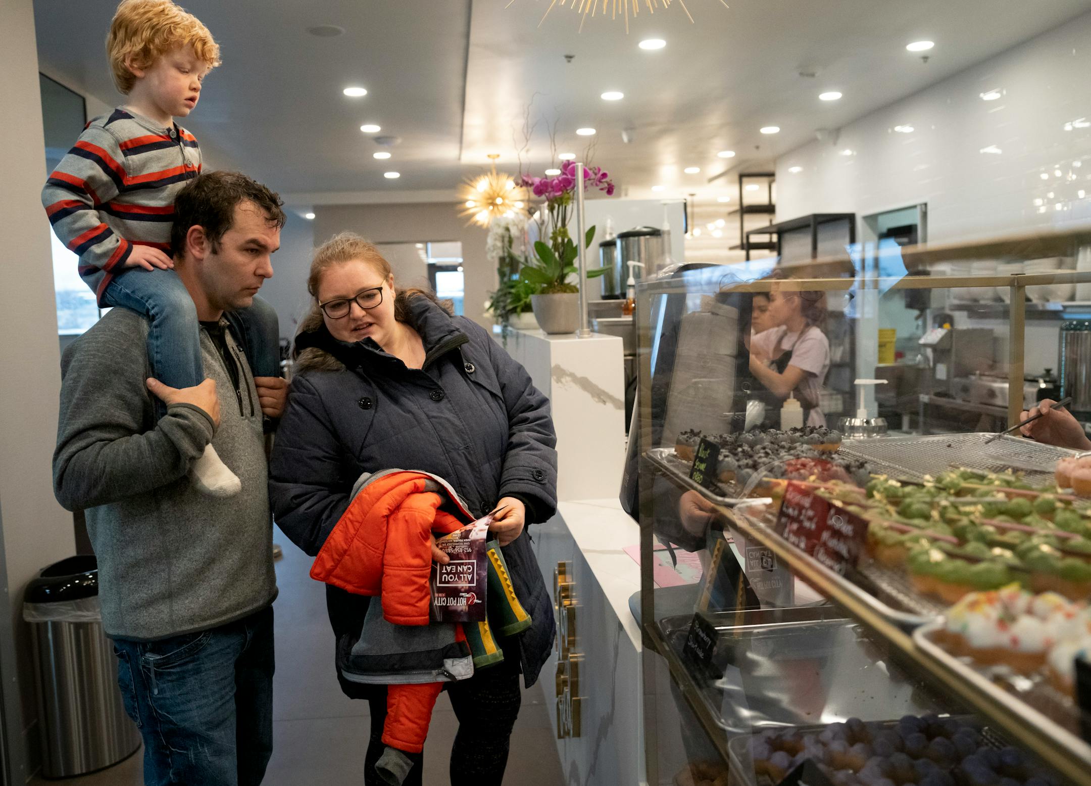 Shannon Clouse, Chris Clouse and their son Owen order doughnuts at Mochi Dough at a soft opening for the new Asia Mall.