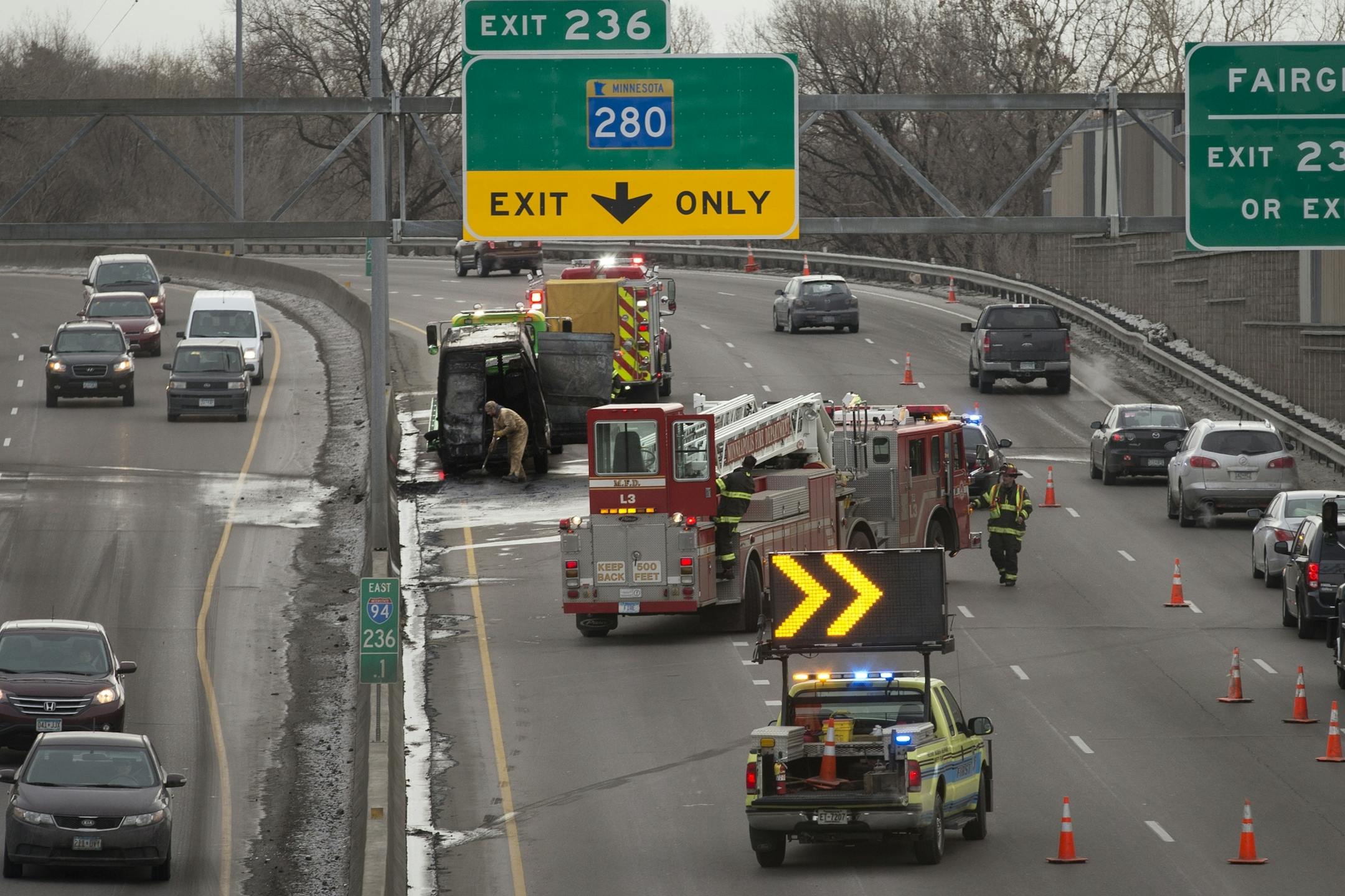 Crews clean up after a van traveling eastbound on I-94 broke down and caught fire, creating a major traffic jam in downtown Minneapolis in the late morning on Tuesday, December 2, 2014.