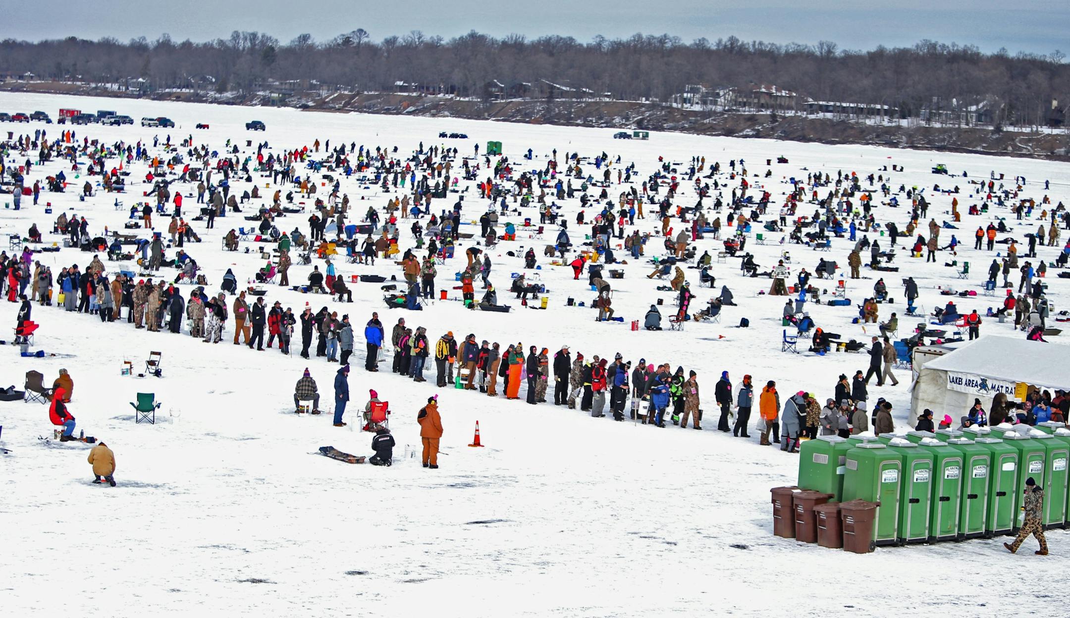 What appears as a long long for the portable bathrooms is actually a line of successful fishing contestants waiting to register their fish on Hole in the Day Bay of Gull Lake during the Ice Fishing Extravaganza Saturday, Feb. 6, 2016, in Brainerd, MN.