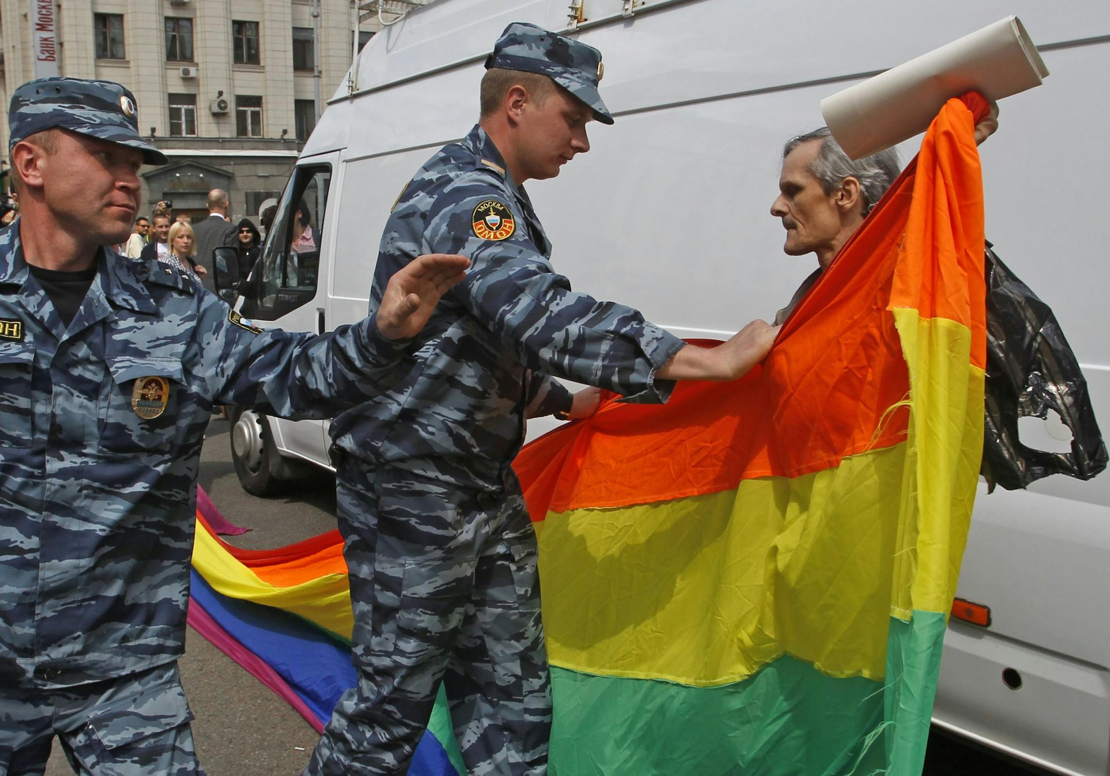 Russian police officers detain a gay rights activist with his flag during an attempt to hold a gay pride parade in Moscow, Russia, Sunday, May 27, 2012. Russian police have detained around a dozen protesters demanding the right to hold a gay pride parade in Moscow. Activists have long petitioned the government for permission to stage such a parade, but have always been denied. (AP Photo/Mikhail Metzel)