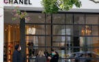 Customers wearing masks waited to enter a Chanel store Wednesday, in the West Hollywood area of Los Angeles. Los Angeles County imposed new restrictio
