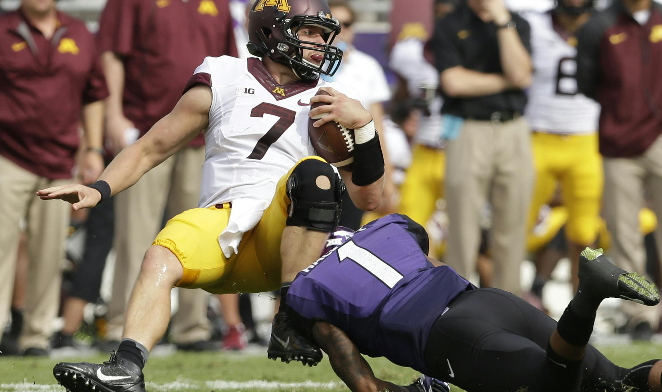 Minnesota quarterback Mitch Leidner (7) is stopped by TCU safety Chris Hackett (1) during the first half of an NCAA college football game Saturday, Sept. 13, 2014, in Fort Worth, Texas. (AP Photo/LM Otero) ORG XMIT: TXMO109