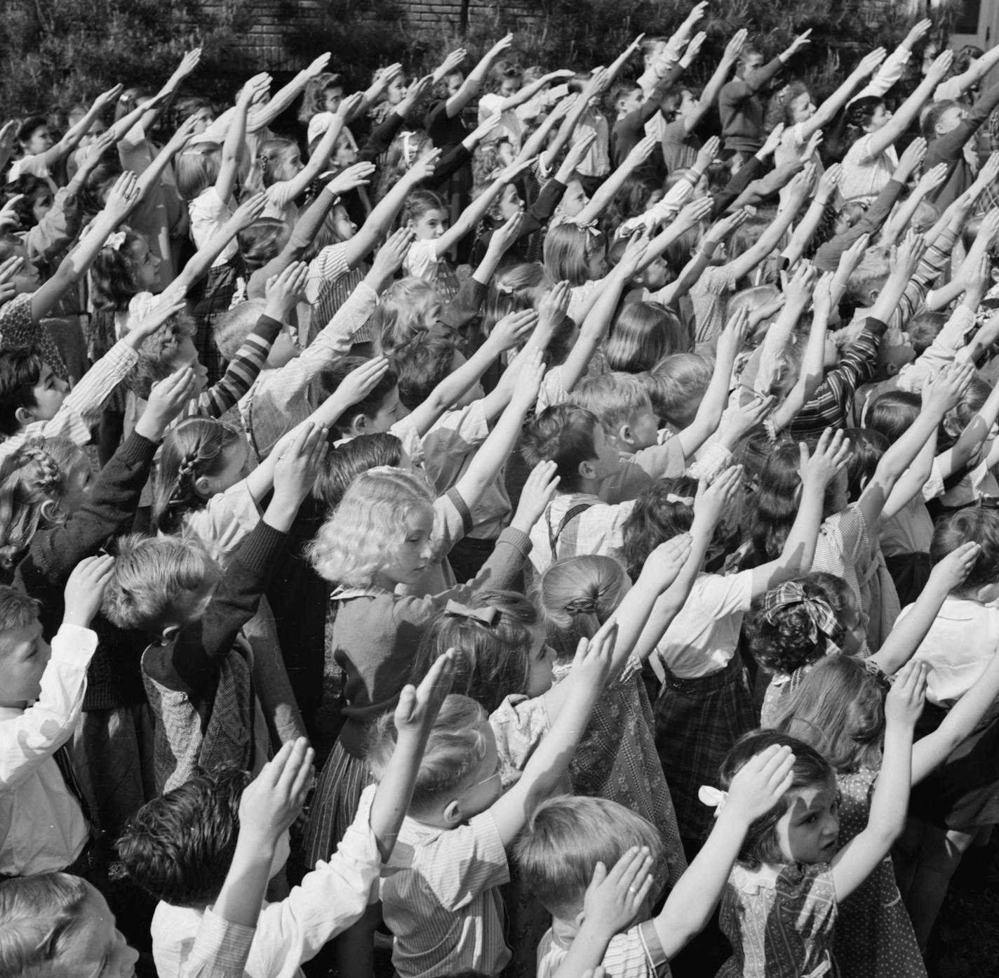 Schoolchildren in Connecticut pledging their allegiance to the flag. Pledge of Allegiance author Francis Bellamy's plan was for every U.S. classroom to partake in a program that would start with the resolution read while standing students faced the flag with a straight-armed, flat-handed salute (later abandoned because it resembled one used in Nazi Germany).