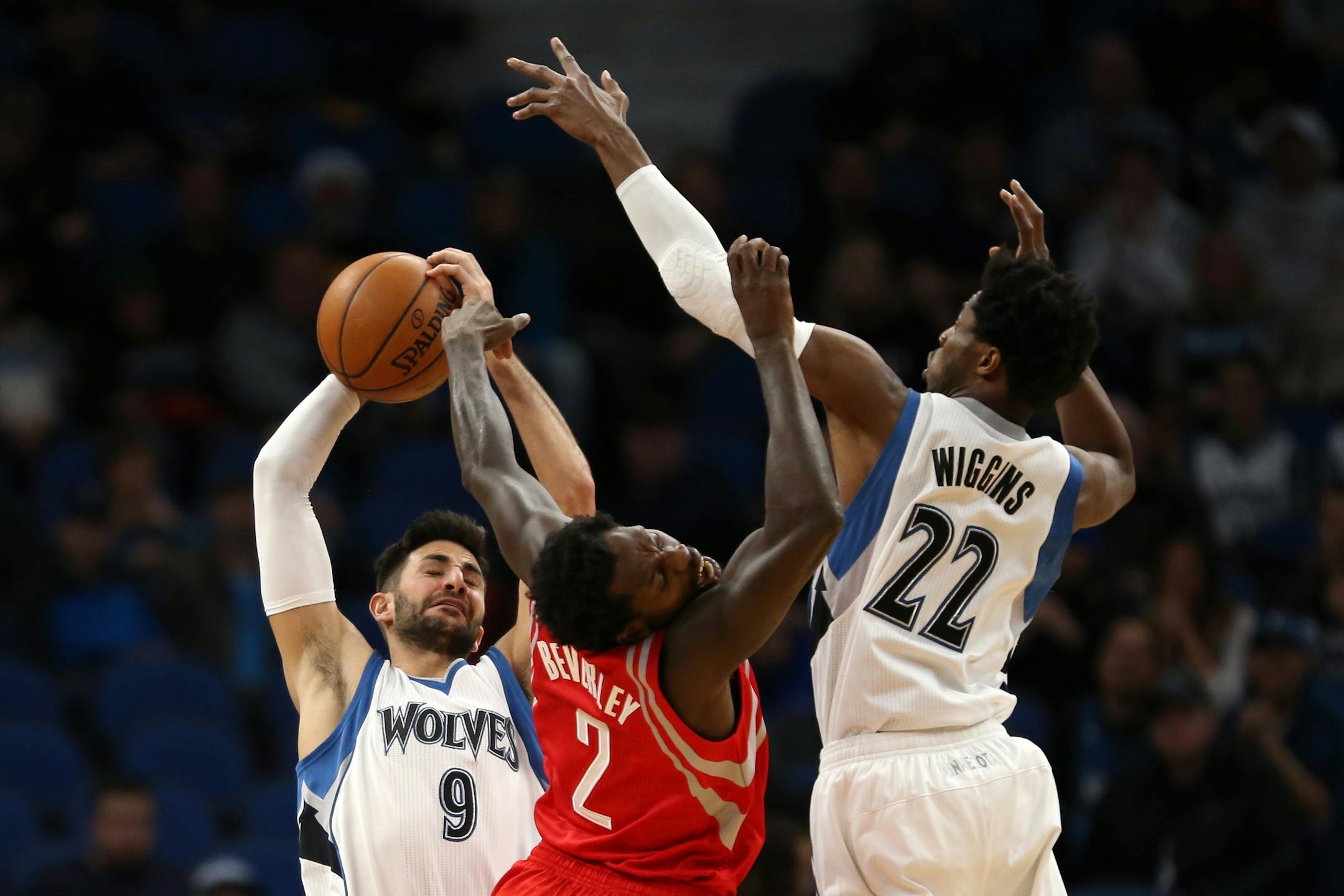 Houston Rockets guard Patrick Beverley (2) gets tangled up with Minnesota Timberwolves guard Ricky Rubio (9) and Minnesota Timberwolves forward Andrew Wiggins (22) as they leapt for a pass in the first half.
