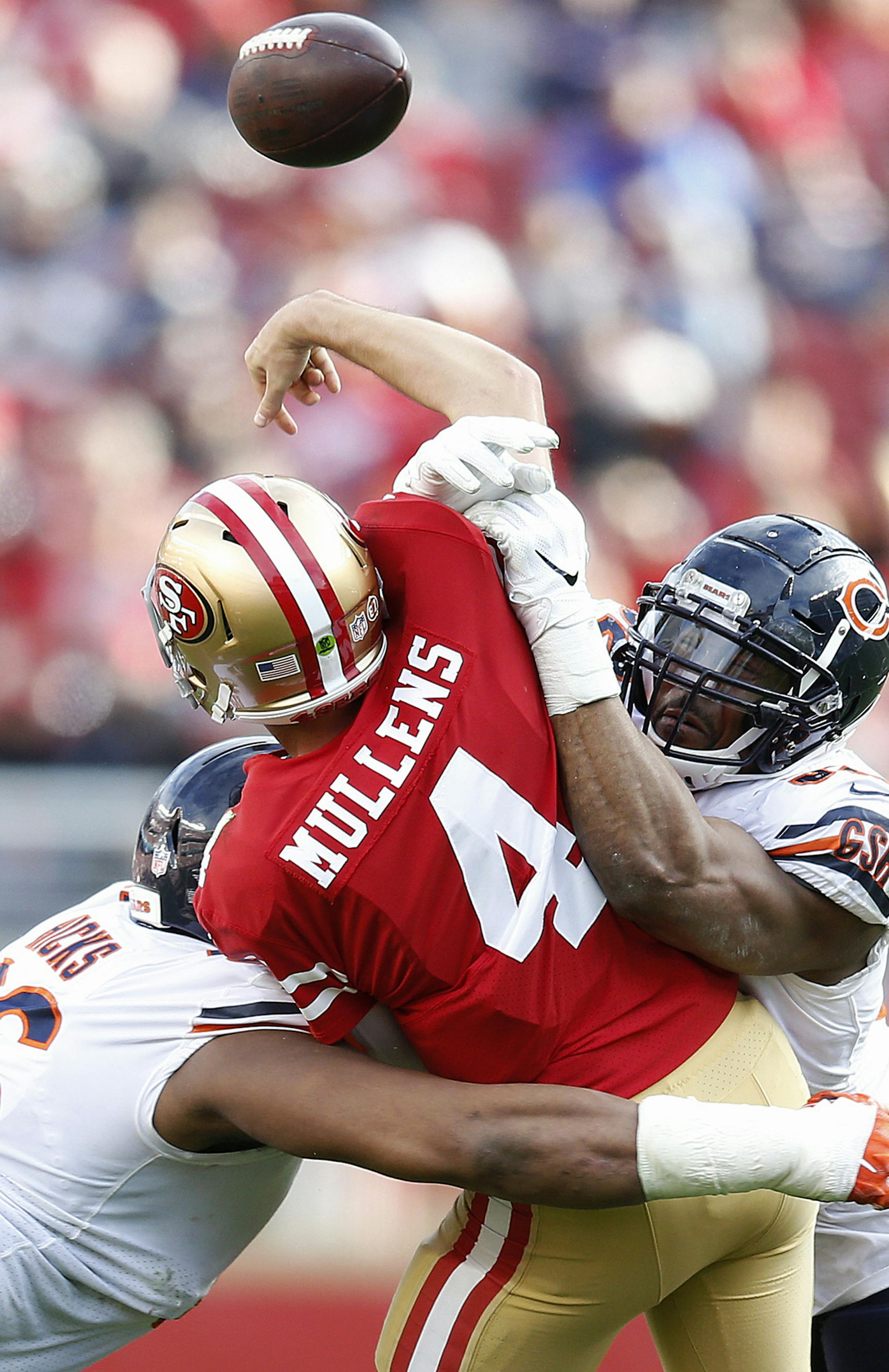 San Francisco 49ers quarterback Nick Mullens (4) is hit by Chicago Bears defensive end Akiem Hicks, left, and outside linebacker Khalil Mack during the second half of an NFL football game in Santa Clara, Calif., Sunday, Dec. 23, 2018. (AP Photo/D. Ross Cameron)