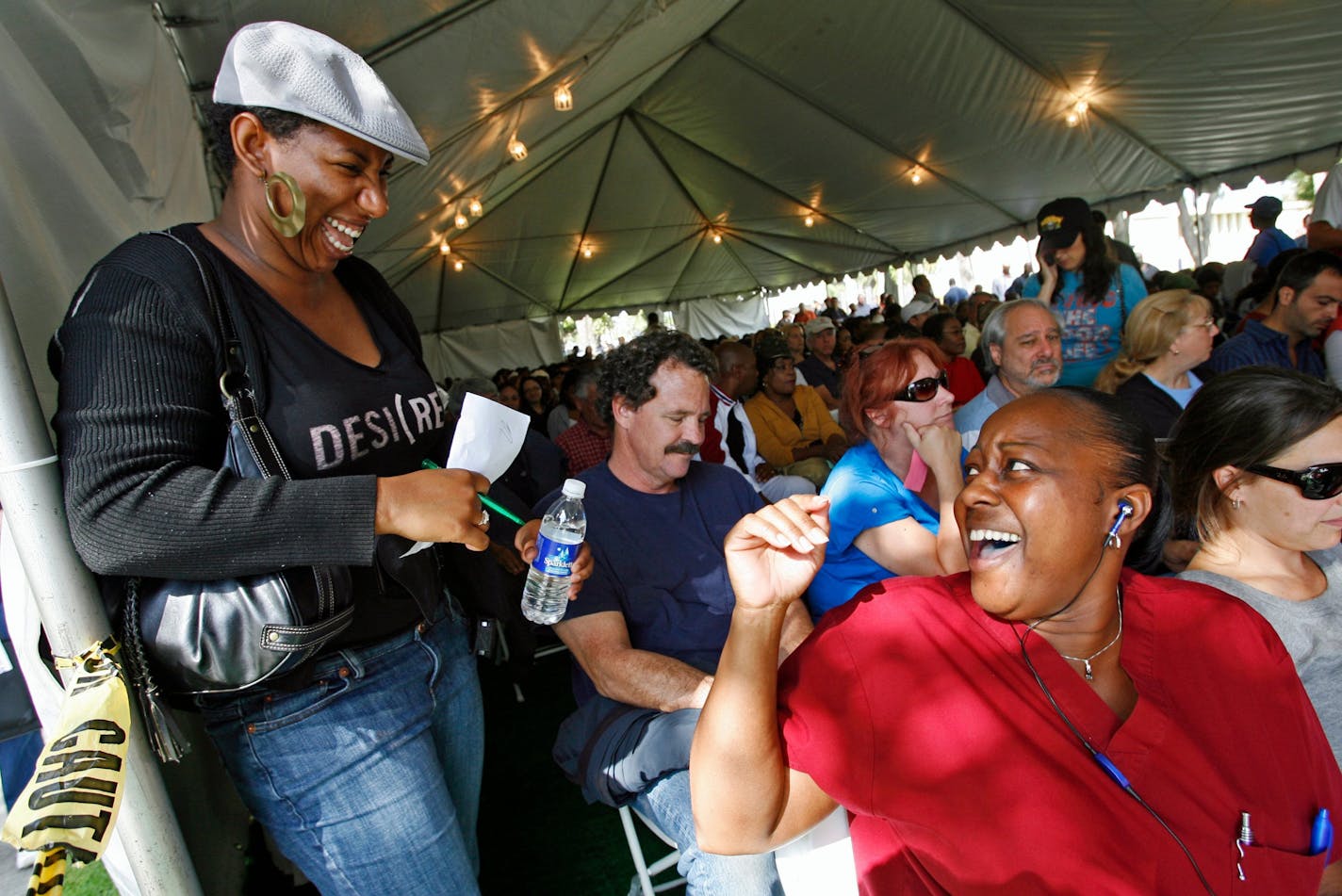 Early voters Keisha Stiger, a case manager with the African American Unity Center, left, and nurse Vicky Warrior, 48, right, cheer as they turn to pick up their ballots following an announcement after a long wait at the County of Los Angeles Registrar-Recorder/County Clerk headquarters in Norwalk, Calif. on Friday, Oct. 31, 2008. (AP Photo/Damian Dovarganes)