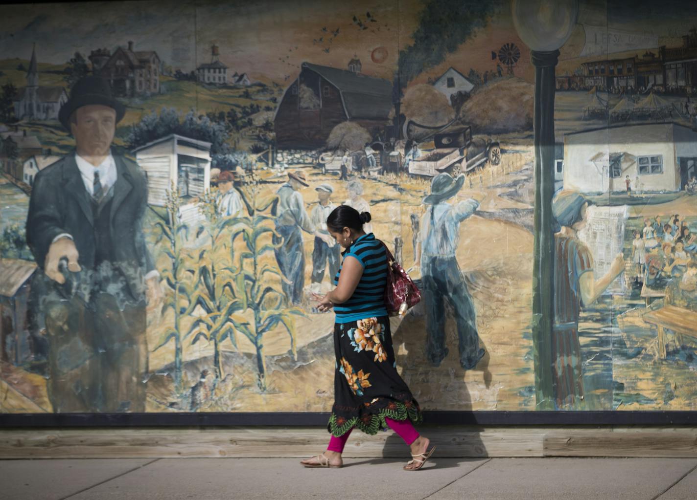 A Micronesian womman walked past a mural depicting the history of Scandinavian Milan, Minn., September 13, 2016. ] RENEE JONES SCHNEIDER &#x2022; renee.jones@startribune.com