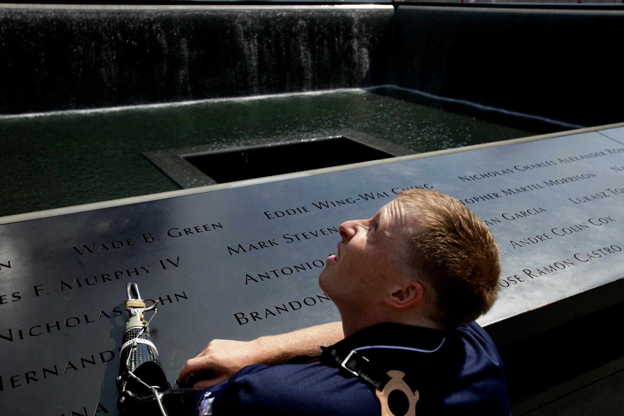 US Marine Cpl. Mark Litynski of New Hope, Minn., looks up at One World Trade while visiting the 9/11 Memorial at ground zero in New York, Wednesday, July 4, 2012. Litynski was visiting the memorial with other wounded veterans as a part of a trip organized by the Stephen Siller Tunnel to Towers Foundation, which is helping to build accessible homes for the wounded veterans. (AP Photo/Seth Wenig)