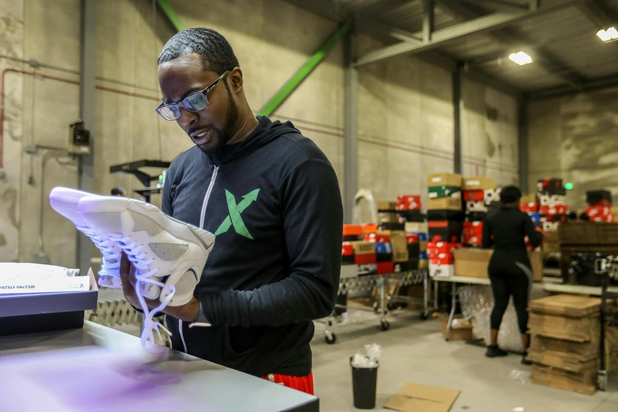 Antonio Gray, 29, of Detroit, worked as a sneaker salesman for six years before becoming a authenticator at Stock X, where he looks over a pair of Jordans at their new authentication center in Detroit on Tuesday, July 3, 2018. Stock X has created day trading for consumer goods and is doing $2 million in sales daily. (Kimberly P. Mitchell/Detroit Free Press/TNS) ORG XMIT: 1235460