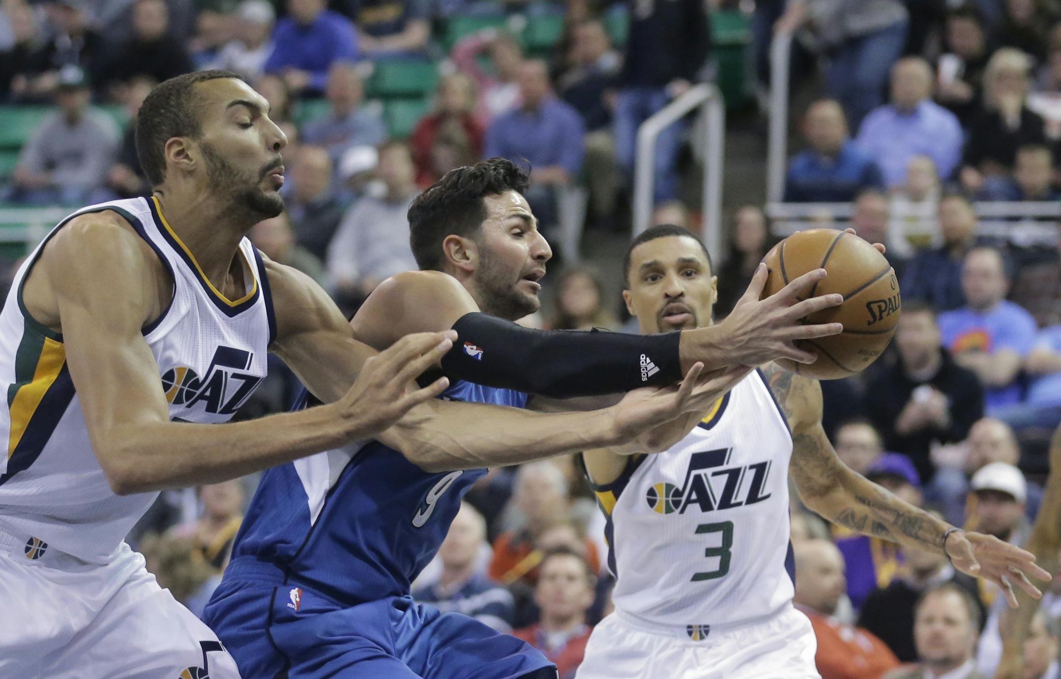 Minnesota Timberwolves guard Ricky Rubio (9) battles with Utah Jazz's Rudy Gobert, left, and George Hill (3) for a loose ball during the first half in an NBA basketball game Wednesday, March 1, 2017, in Salt Lake City.