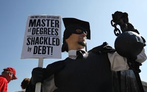 In this Oct. 6, 2011 photo, Gan Golan of Los Angeles, dressed as the "Master of Degrees," holds a ball and chain representing his college loan debt du