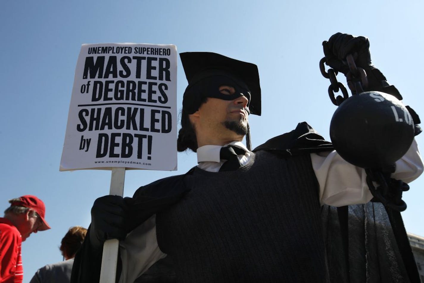 In this Oct. 6, 2011 photo, Gan Golan of Los Angeles, dressed as the "Master of Degrees," holds a ball and chain representing his college loan debt during Occupy DC activities in Washington. As President Obama prepared to announce new measures Wednesday to help ease the burden of student loan debt, new figures painted a demoralizing picture of college costs for students and parents: Average in-state tuition and fees at four-year public colleges rose an additional $631 this fall, or 8.3 percent,