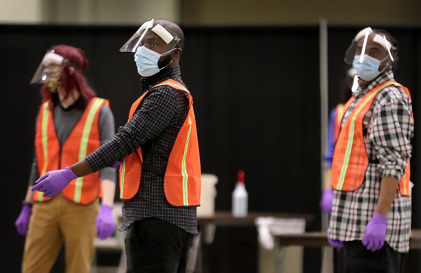 Clinical workers waited for people to enter a new saliva testing center for COVID-19 in the Minneapolis Convention Center on Monday in Minneapolis.