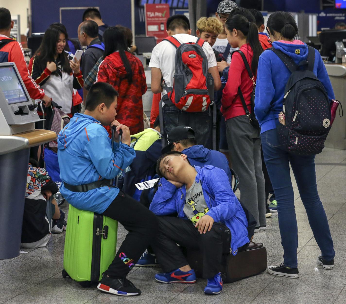 Yu You Yang, 12 from Beijing, China napped at Hartsfield-Jackson International Airport in Atlanta, Ga., while waiting in line at a Delta counter Wednesday, Aug. 10, 2016. Delta fliers faced delays, cancellations and more headaches Wednesday as the Atlanta-based airline struggled with its computer systems for the third straight day. Nearly 300 flights were canceled by the afternoon, in addition to the 800 scrapped Tuesday and 1,000 canceled Monday. Hundreds of other flights were delayed Wednesday