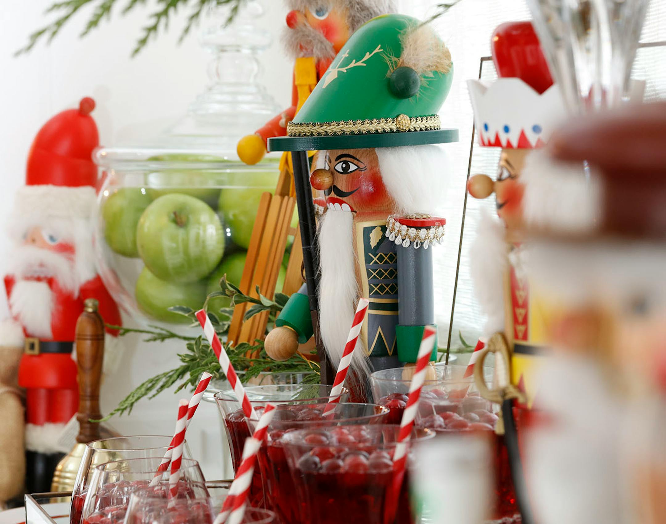 Shades of red and green are repeated in the nutcrackers, fresh greenery, beverages and apples.