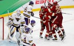 Denver's Shai Buium (26) and teammates celebrate a goal by Ryan Barrow against Minnesota State's Dryden McKay (29) during the third period of the NCAA