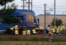 Workers set about getting a Blue Line train back on track after it derailed around 5 a.m. near Franklin Avenue, while a bicyclist continued his commut