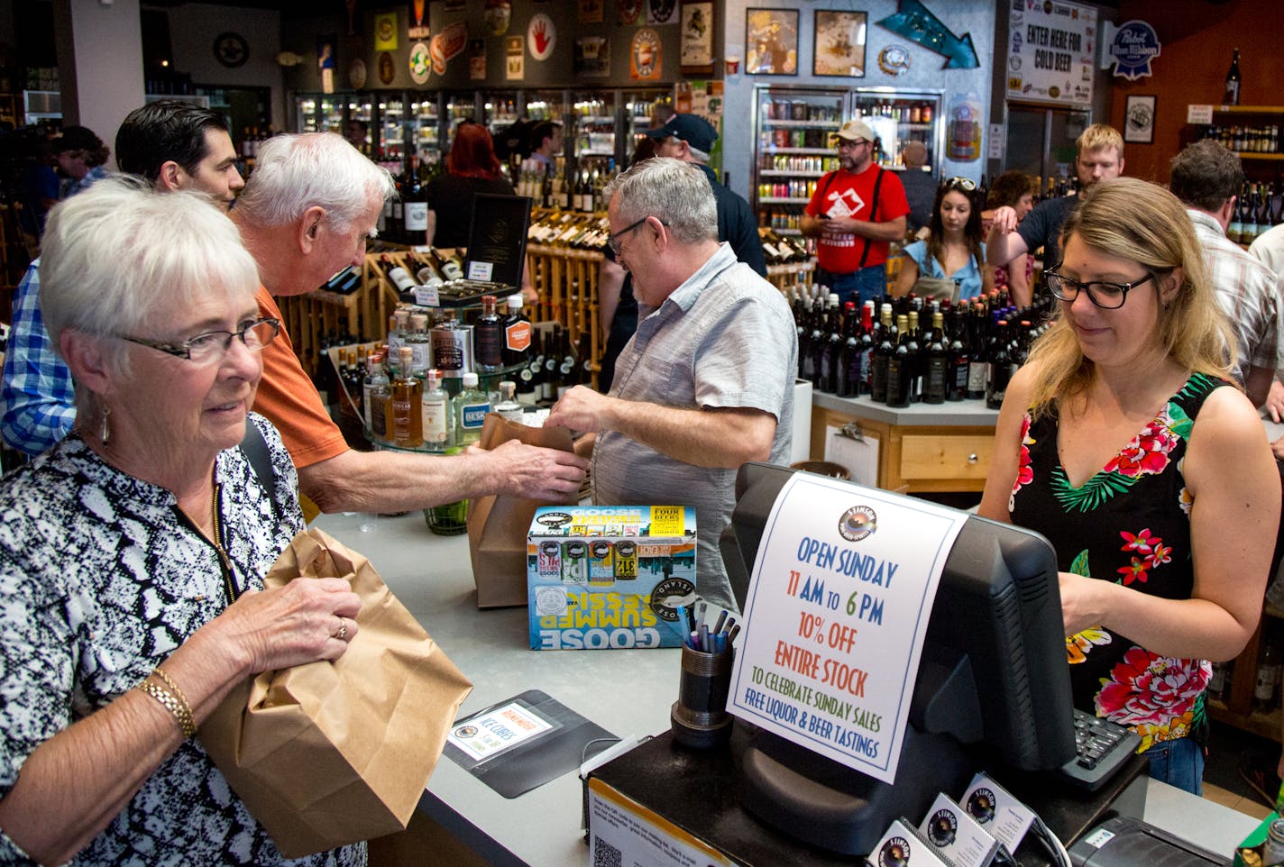 Jessica Jeruzal (right) checks out customers at Stinson Wine, Beer, and Spirits on Sunday. ] COURTNEY PEDROZA &#x2022; courtney.pedroza@startribune.com July 2, 2017;Minneapolis ; Stinson Wine, Beer, and Spirits opens for the first time on a Sunday after the new state law allowed liquor stores to be open; House Speaker Kurt Daudt,